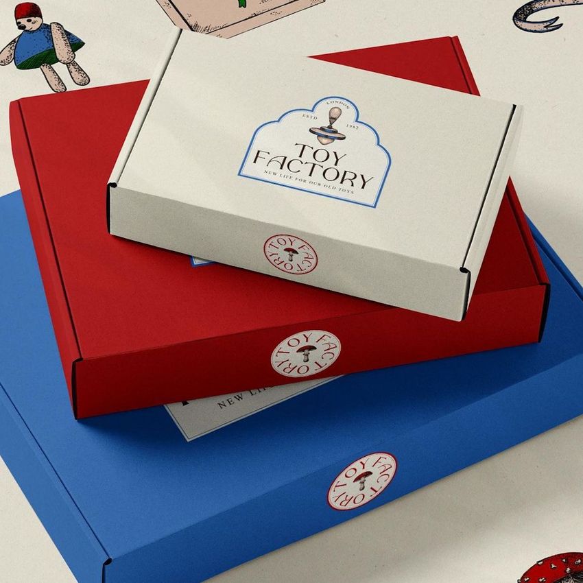 Mailing box mockup featuring three stacked boxes in white, red, and blue with playful toy-themed graphics and labels.