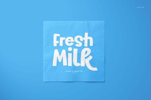 Square napkin mockup featuring a bold white 'Fresh Milk' print on a blue background, shown from a top view.