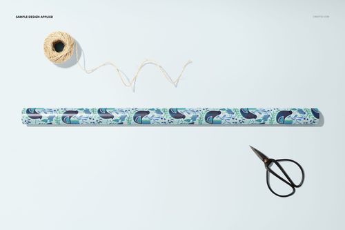 Gift wrapping paper mockup with marine pattern, displayed on a white background with scissors and string for packaging.