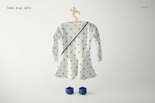 Long-sleeve baby dress mockup with a blue floral pattern, displayed on a bunny-shaped hanger with matching shoes.