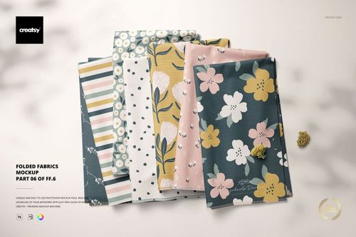 Folded fabric stack mockup featuring multiple designs, including flowers, stripes, and abstract prints, top perspective.