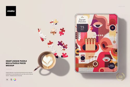 Heart-shaped jigsaw puzzle pieces scattered next to a rectangular puzzle box with abstract colorful artwork, top view.