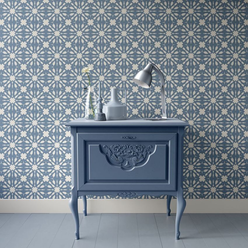 Interior scene mockup showing a blue vintage nightstand against a blue and white geometric tile-patterned wall with decorative items.