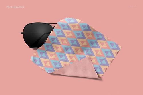 PSD mockup of a microfiber cleaning cloth featuring a colorful triangle pattern, shown with sunglasses on a pink surface.