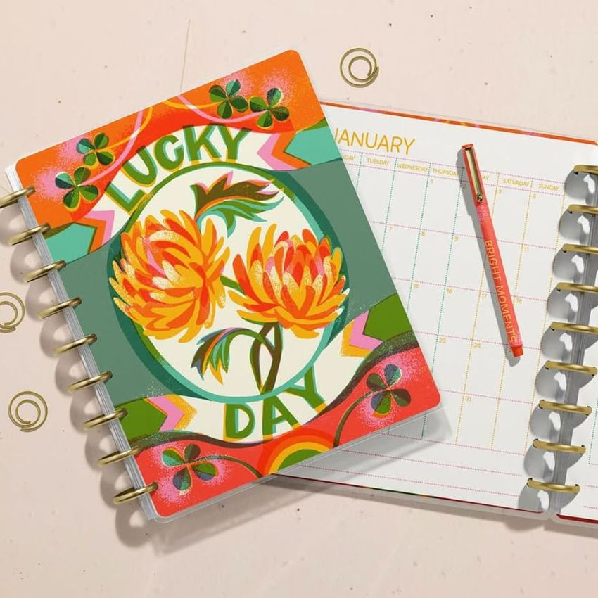 Spiral planner mockup featuring a vibrant floral cover with bold text, next to an open planner showing a monthly layout.