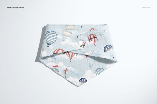 PSD mockup of a baby muslin bandana displayed flat, decorated with colorful hot air balloons and cloud motifs.