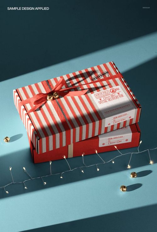 Christmas-themed PSD mockup featuring two festive shipping boxes with red accents, ribbon, and string lights.