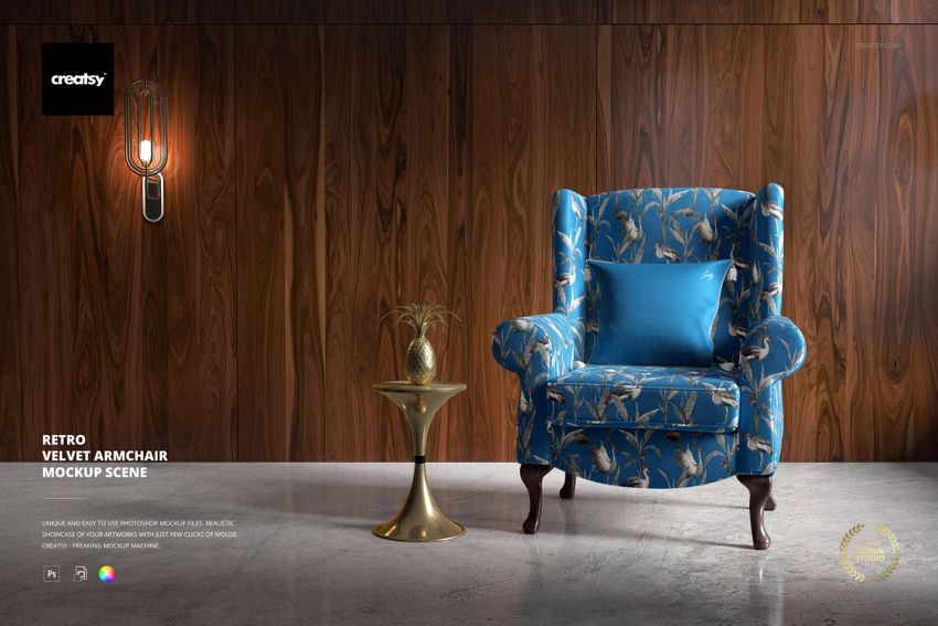 Retro velvet armchair mockup in blue with gold leaf design, placed beside a small gold table and decorative plant.