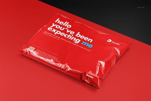 Red poly mailer packaging with white text, displayed at an angle on a red and black surface in a PSD mockup.