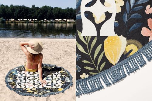 Close-up of round beach towel mockup featuring blue fringe and botanical design, shown in outdoor beach setting.