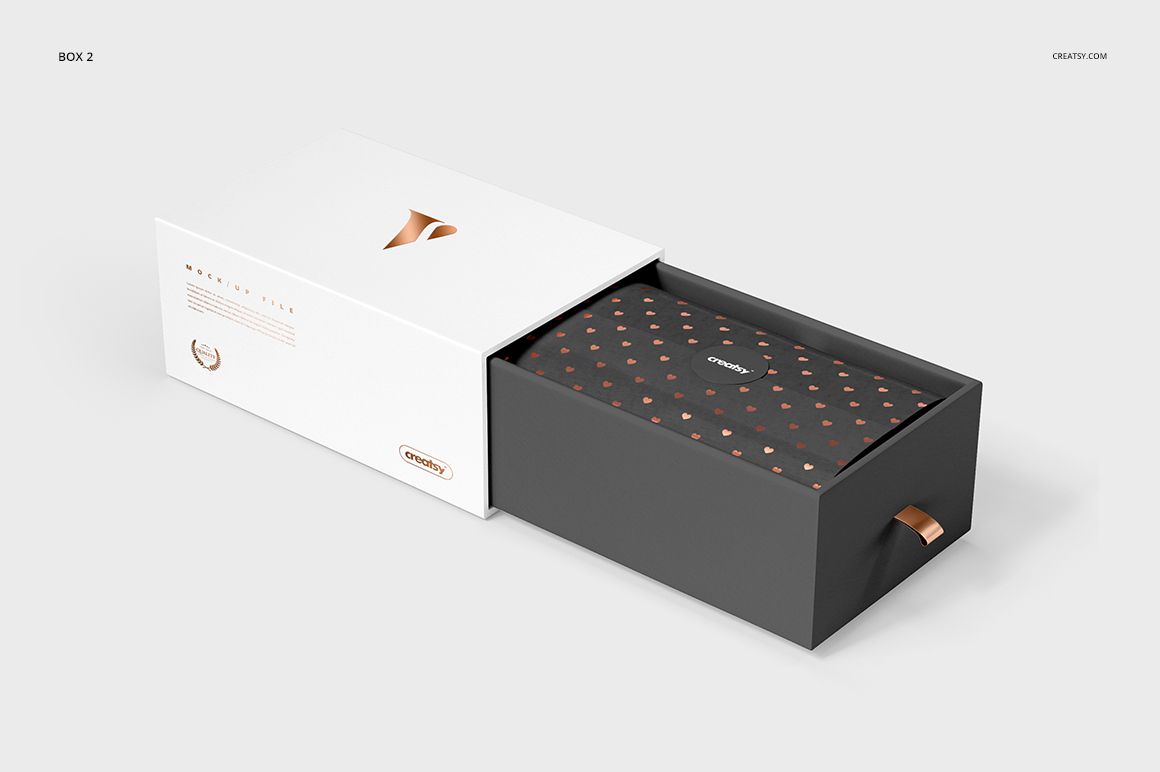 Front view of a gift box mockup set showing a white sliding lid and a dark base with copper accents on a light background.