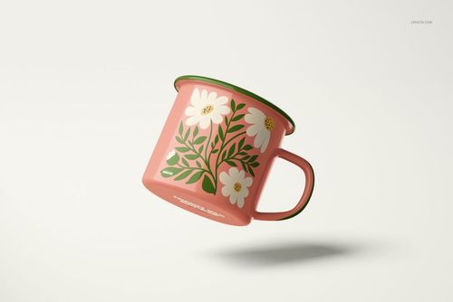 Enamel mug mockup featuring a pink surface, green edge, and white flowers, displayed at an angled side view.