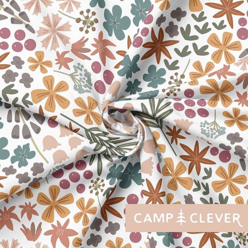 Creased fabric mockup featuring a colorful floral pattern with orange, pink, green, and purple elements on a white background.