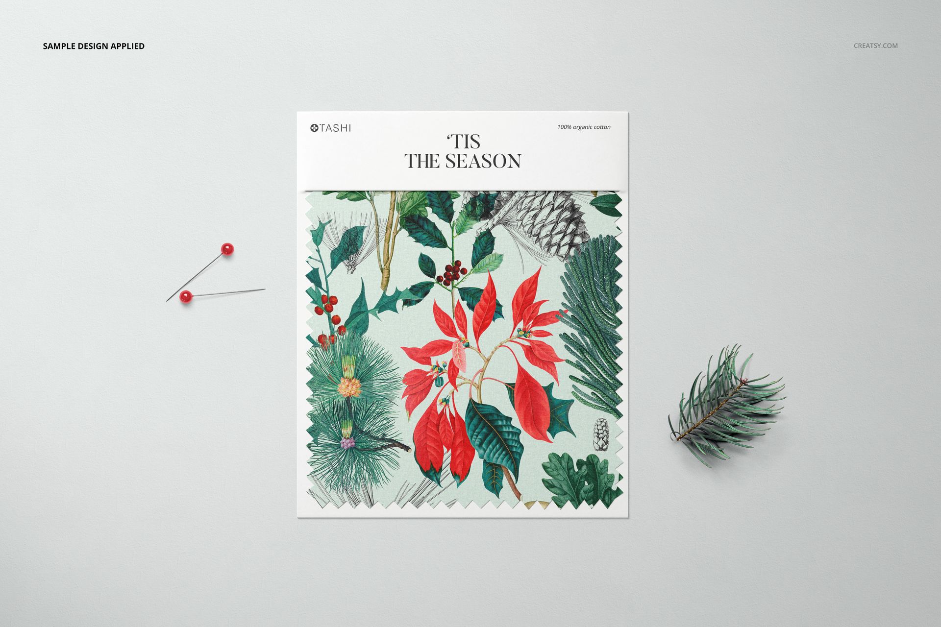 Fabric swatch mockup displayed from a top view, featuring a botanical pattern with red and green leaves on a light background.