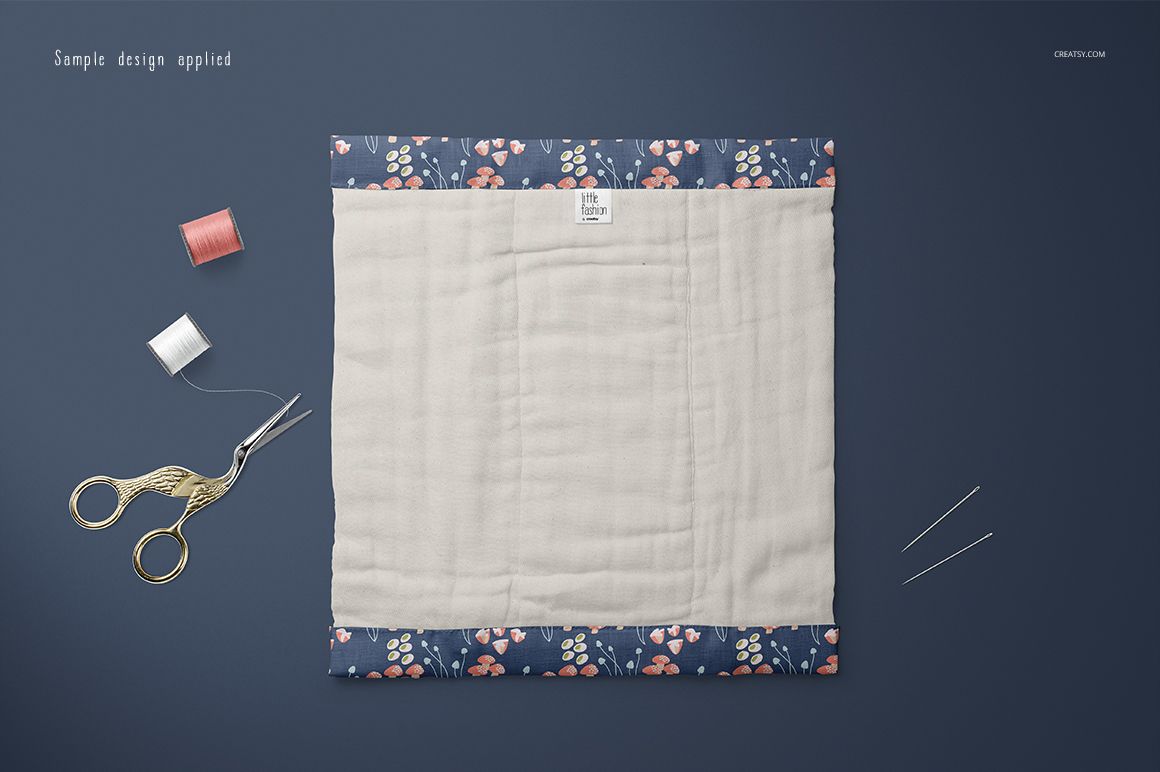 Burp cloth mockup displayed flat on a dark surface, featuring a beige center and floral patterned border edges.