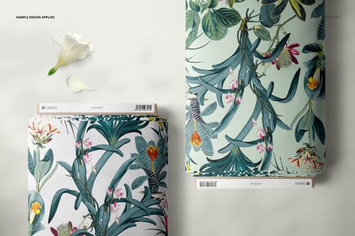 Top-down perspective of fabric bolt mockup set showing floral designs, cardboard wraps, and stickers, placed on a neutral background.