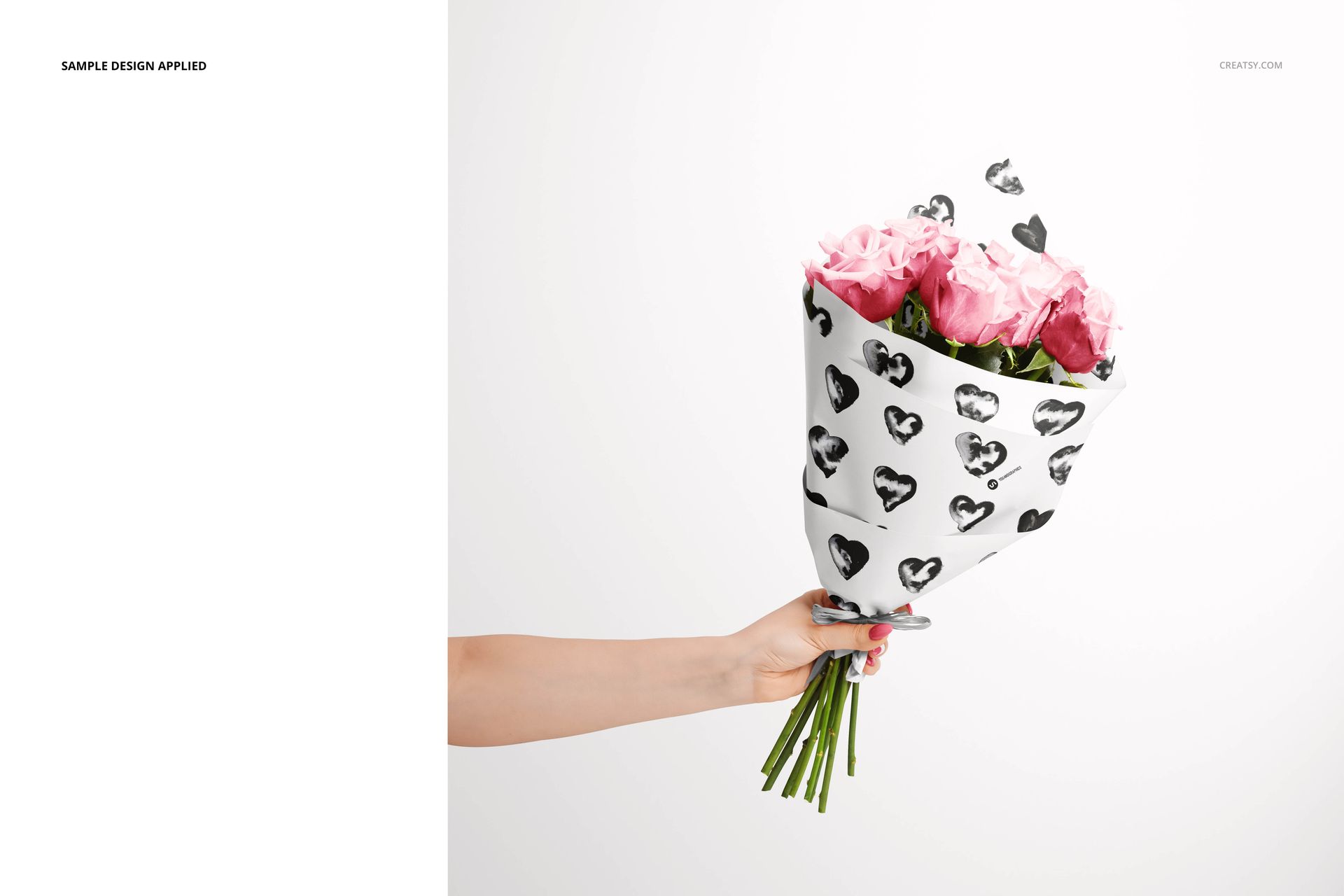 Bouquet of pink roses wrapped in decorative paper featuring black hearts, displayed in a front view mockup scene.