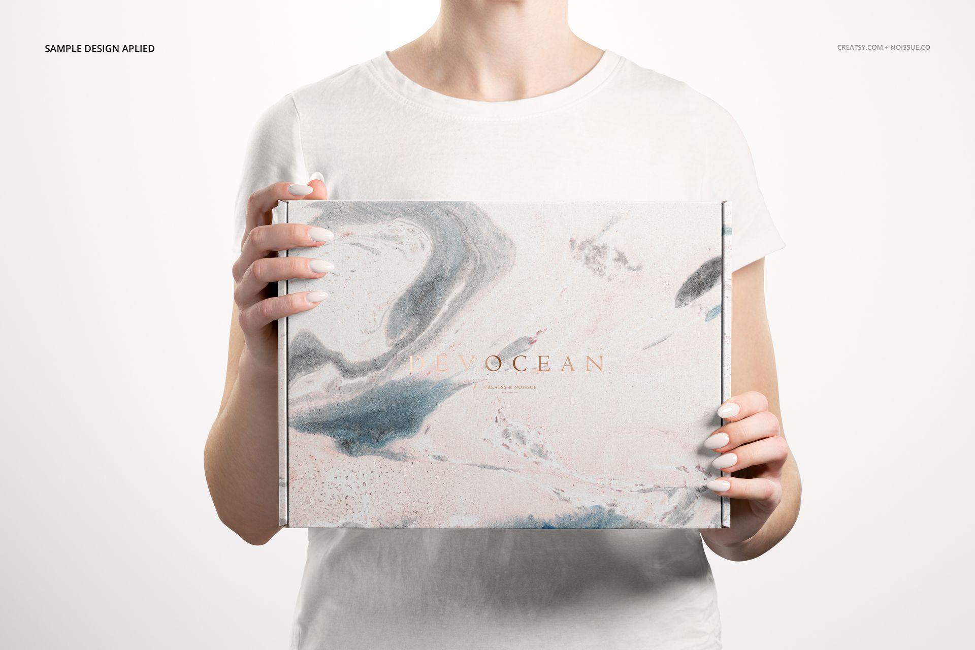 Front view of a mailing box mockup with abstract marble design in soft blue and beige, held by a person in a white shirt.