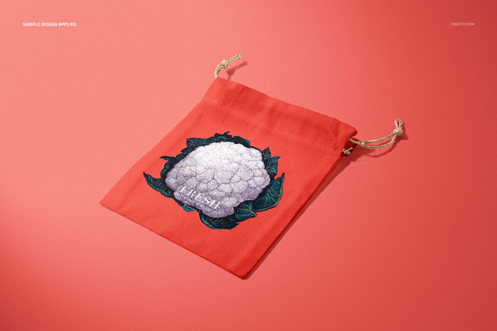 Coral-colored linen pouch mockup featuring a cauliflower design, shown with drawstrings on a solid pink background.