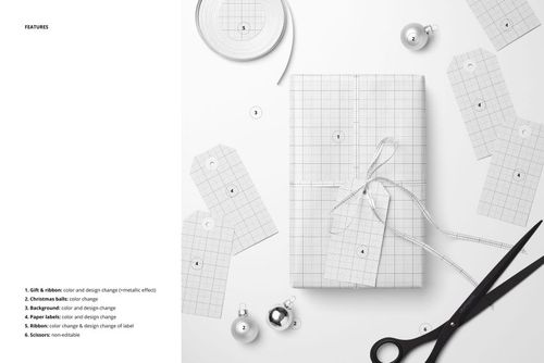 Top view of a Christmas gift mockup featuring grid-patterned wrapping paper, ribbon, scissors, and scattered paper labels.