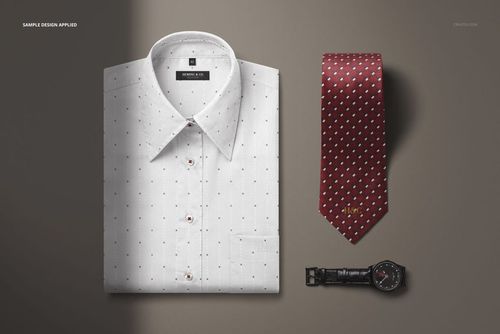PSD mockup showing a folded white dress shirt, patterned burgundy tie, and black leather strap wristwatch from above on a gray backdrop.
