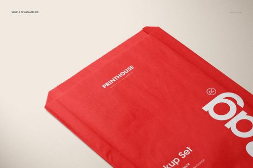 Red sandwich or snack paper bag mockup shown from a top angle on a light beige surface, featuring white text.