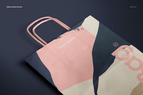 Twisted handles paper bag mockup featuring abstract pink, navy, and cream design, shown from a top angle.