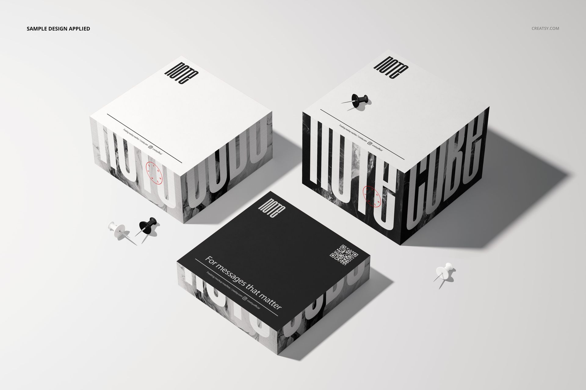 Three note cube mockups in black and white, shown from a top and angled view, with push pins on a light surface.