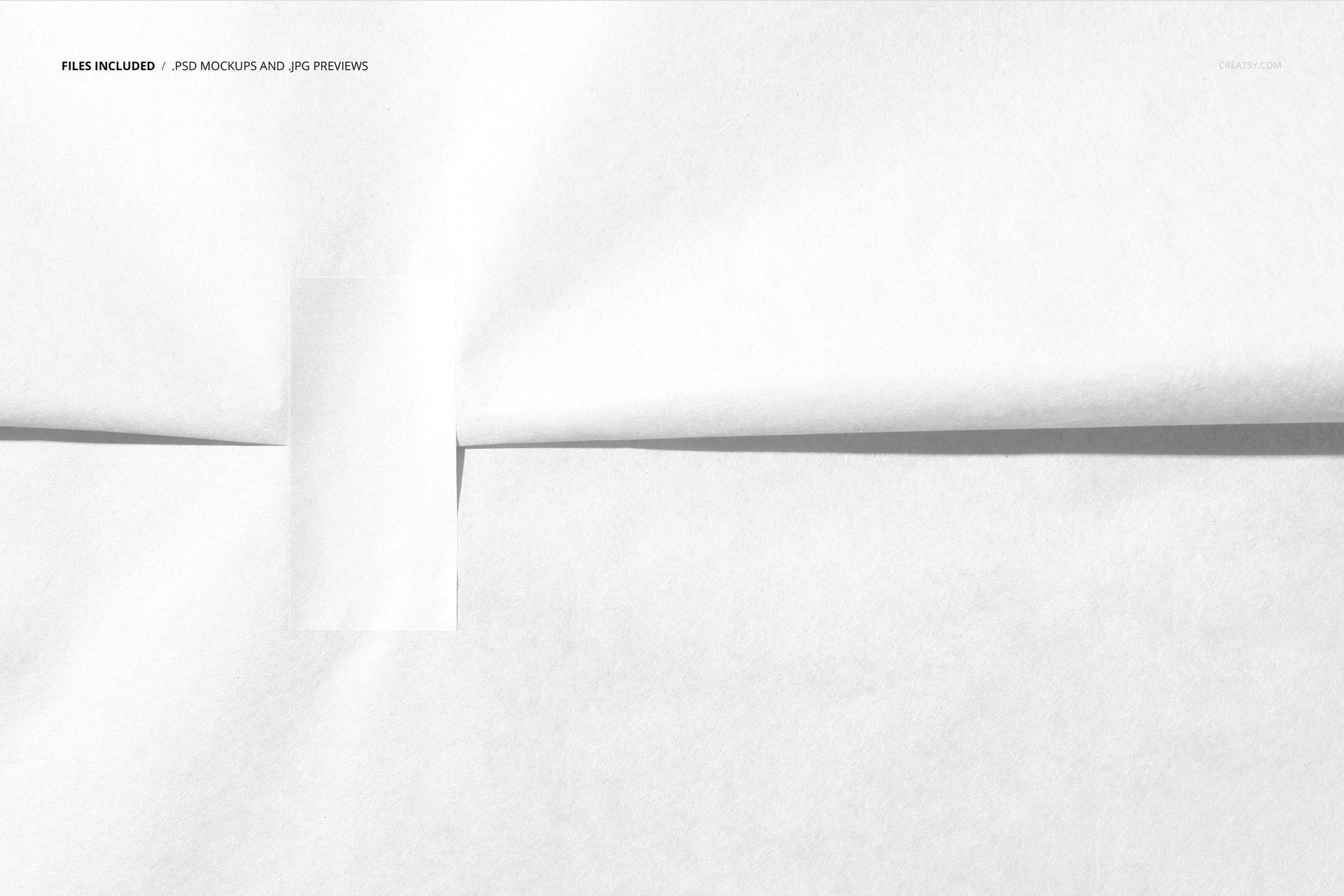 Minimalist wrapping paper mockup featuring a smooth white surface and a centered rectangular sticker from above.