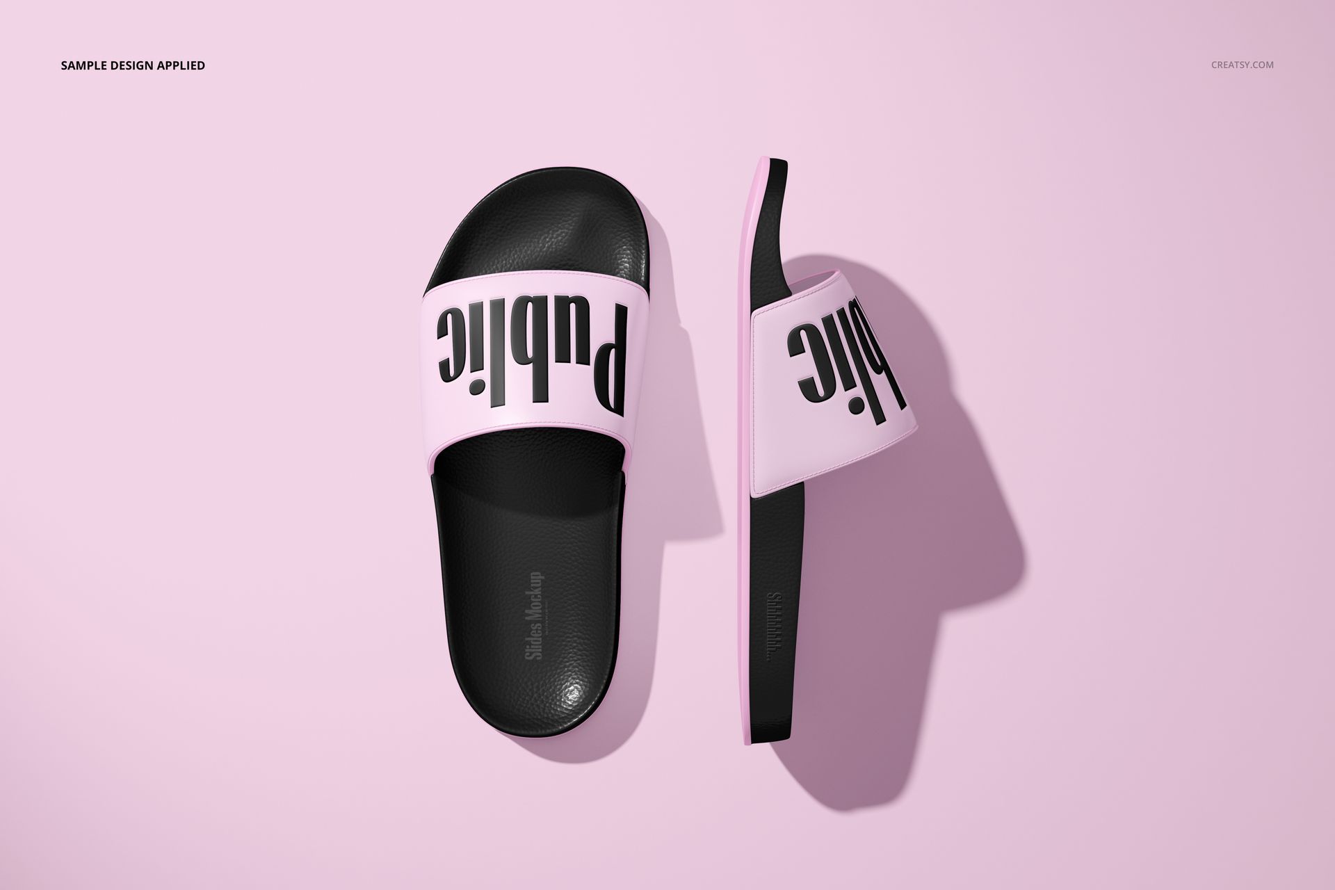 Slide sandals mockup featuring two slip-on sandals with black soles and light pink straps, displayed on a pale pink surface.