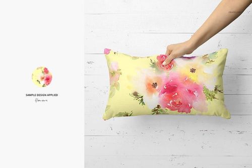 PSD mockup showing a rectangular pillow with pink and green flower prints, presented on a white wood backdrop.