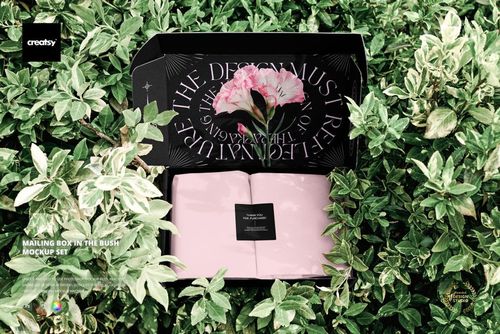 Mailing box mockup with a floral interior design, displayed open among green leafy bushes, top view perspective.