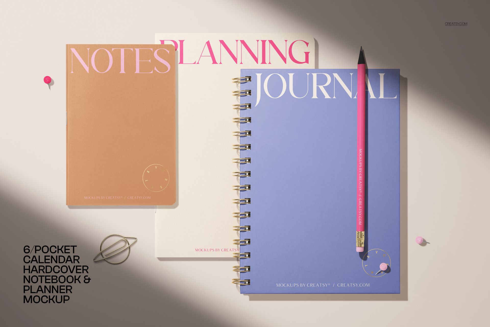 Stationery mockup showing three notebooks in blue, beige, and brown, with a pencil and small decorative props.