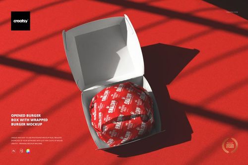 PSD mockup of an open burger box with a burger wrapped in red paper, viewed from above on a vibrant red background.