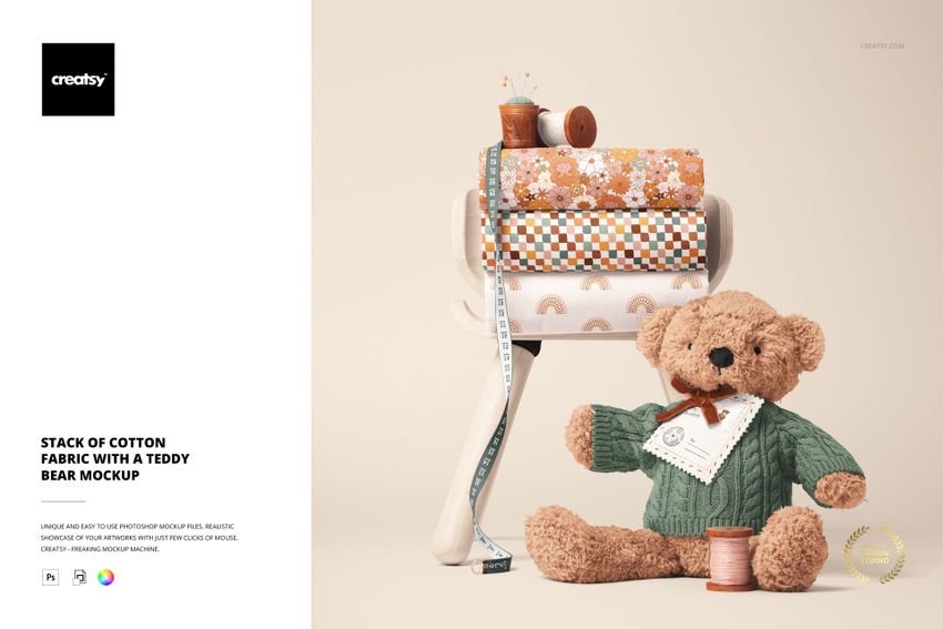 PSD mockup showing assorted cotton fabric rolls with floral and rainbow designs, accompanied by a teddy bear and sewing accessories.