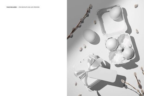 Easter egg boxes mockup showing an open and closed box, white eggs, ribbon, and catkins arranged on a pale surface.