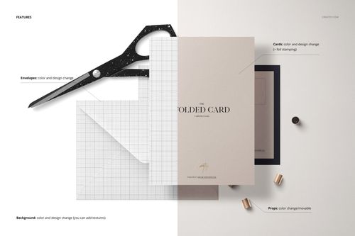 Folded card mockup displayed on a split white and grid background with envelopes, scissors, and small metallic props.