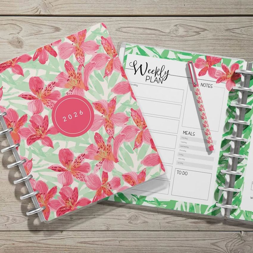 Spiral planner mockup featuring a closed notebook with pink flowers and an open planner displaying a weekly schedule layout.