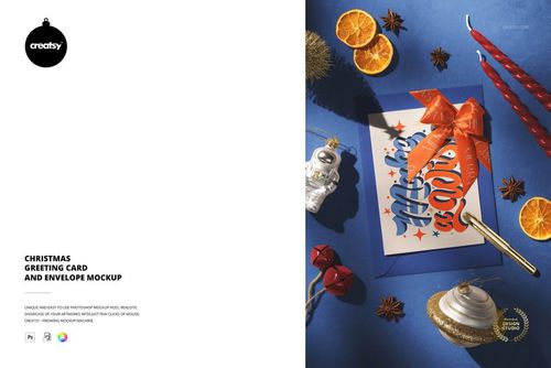 Christmas greeting card and envelope mockup featuring a festive design with a large red bow, surrounded by holiday ornaments and dried orange slices on a blue surface.