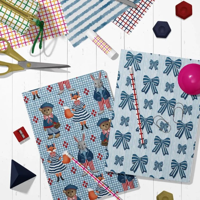 Stationery mockup featuring two A4 notebooks on a white geometric surface, one with a blue bow pattern and one with illustrated animals.