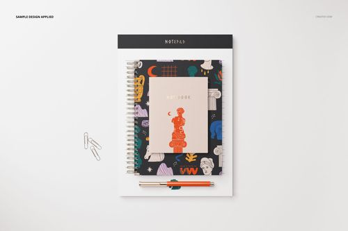Stationery set mockup featuring a spiral notebook, notepad, and pen arranged on a white surface in top view.
