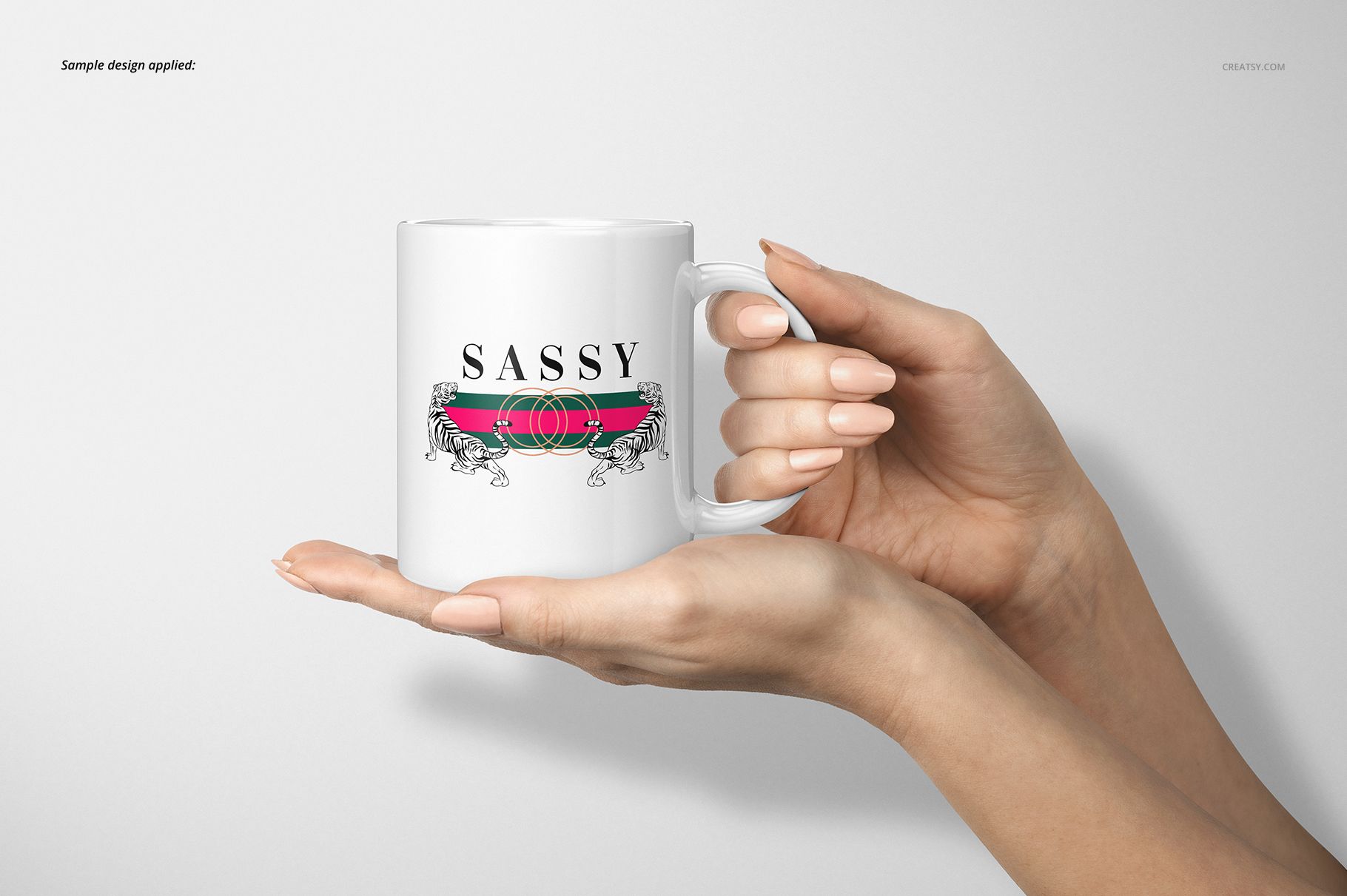 Front view of a white 11oz mug with a decorative design, held in both hands against a plain light background.