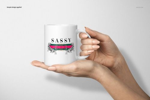 Front view of a white 11oz mug with a decorative design, held in both hands against a plain light background.