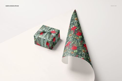 Gift wrapping paper mockup featuring a green and red floral pattern, with a wrapped box and a curled sheet on a white surface.