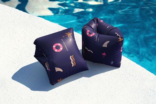 PSD mockup of swimming sleeves with a navy base and pink, white, and yellow summer icons, displayed on pool edge.