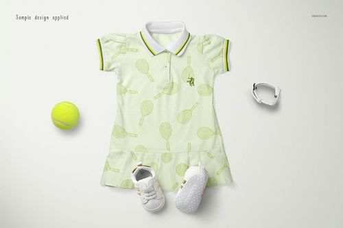 Front view of a kids polo dress mockup with tennis racket pattern, displayed with white shoes, bracelet, and tennis ball.