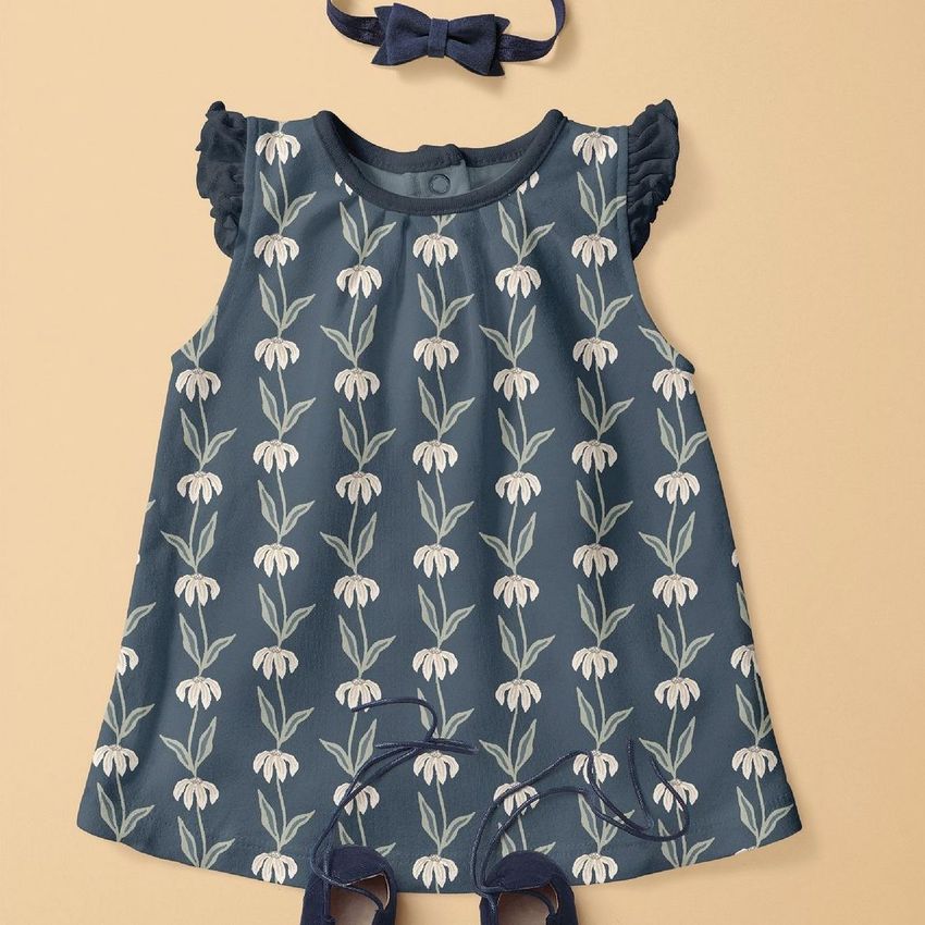 Baby dress mockup featuring a navy blue dress with white coneflower pattern, matching bow headband, and shoes on beige background.