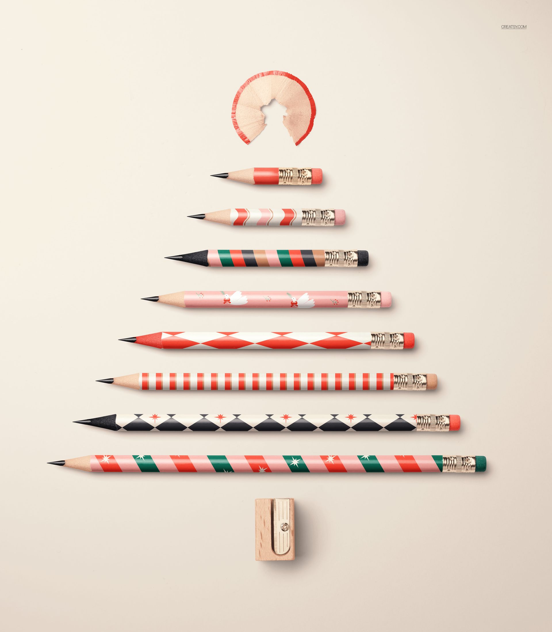 PSD mockup featuring pencils with holiday designs laid out in a tree shape, pencil shavings at the top, and a sharpener at the base.
