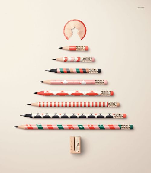 PSD mockup featuring pencils with holiday designs laid out in a tree shape, pencil shavings at the top, and a sharpener at the base.