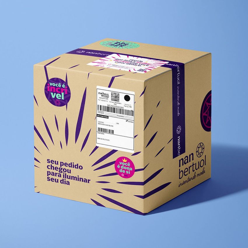 Shipping label mockup featuring a cardboard box with bold purple graphics, stickers, and readable text on a blue background.